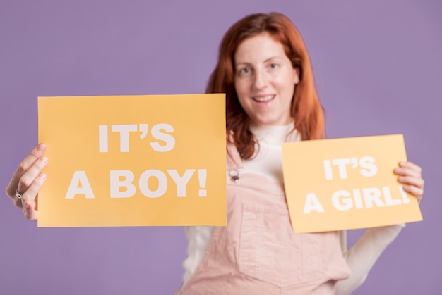 Low angle pregnant woman holding paper with baby gender