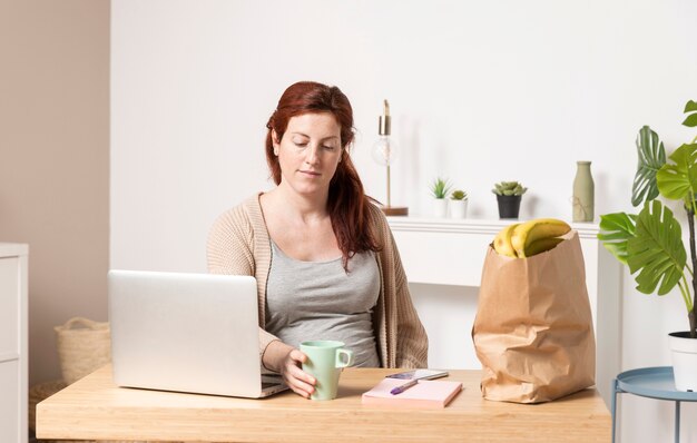 Low angle pregnant woman at home