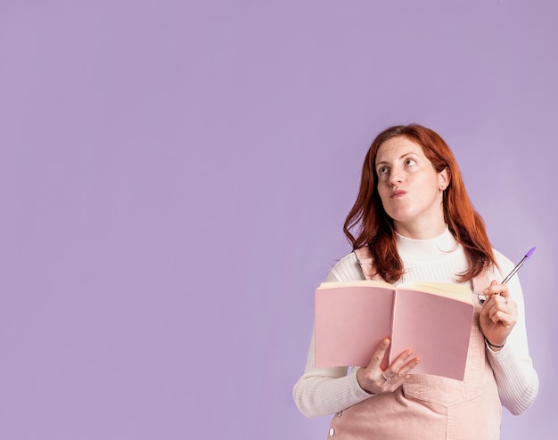 Low angle pregnant woman reading book with copy-space