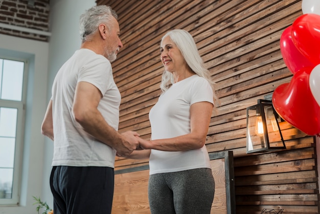 Free photo low angle senior couple holding hands