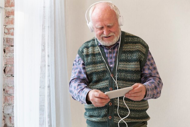 Low angle senior playing music on phone