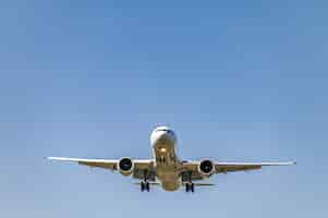 Free photo low angle shot of an airplane flying closer at daytime