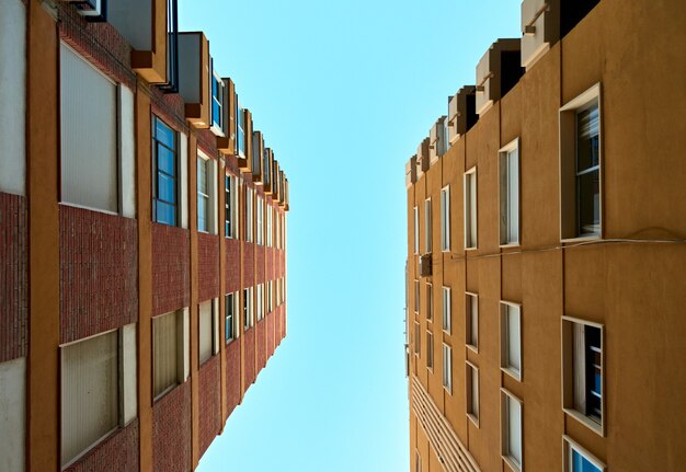 Low angle shot of apartment buildings against clear sky background