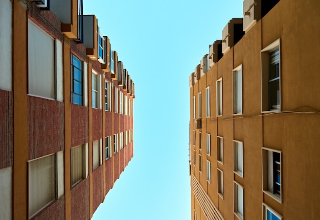 Снимок под низким углом жилых домов на фоне ясного неба