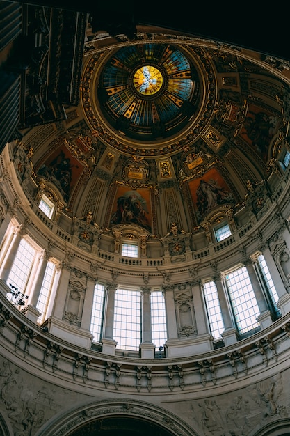 Low angle shot of the beautiful ceiling and the windows and paintings in an old building