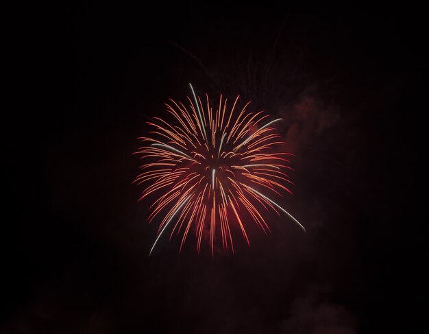 Low angle shot of a beautiful red firework isolated on black sky