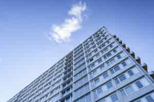 Free photo low angle shot of a big building under a cloud in the beautiful blue sky