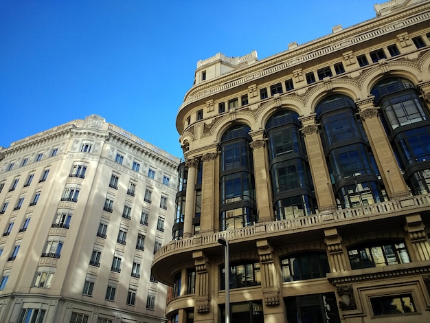 Low angle shot of buildings in Spain under a clear blue sky