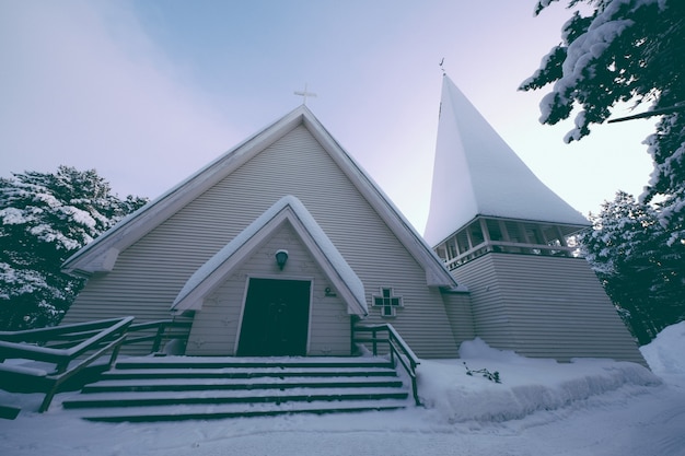 Low angle shot of a chapel covered with thick snow in winter