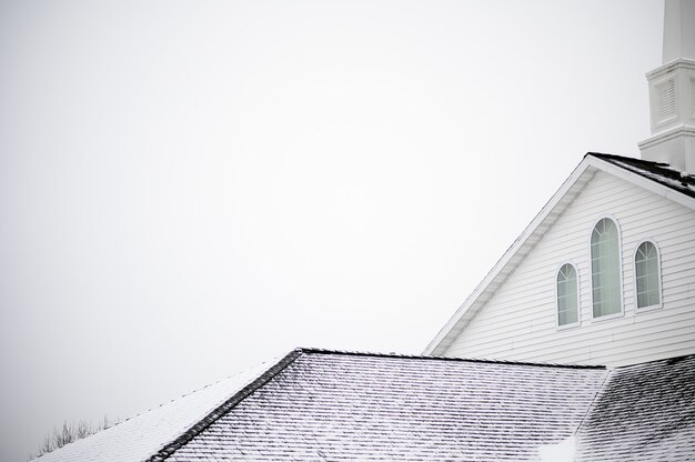 Low angle shot of a church with a staple under the bright sky