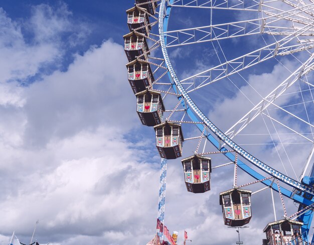 雲でいっぱいの空の下を回転する円形のカルーセルのローアングルショット