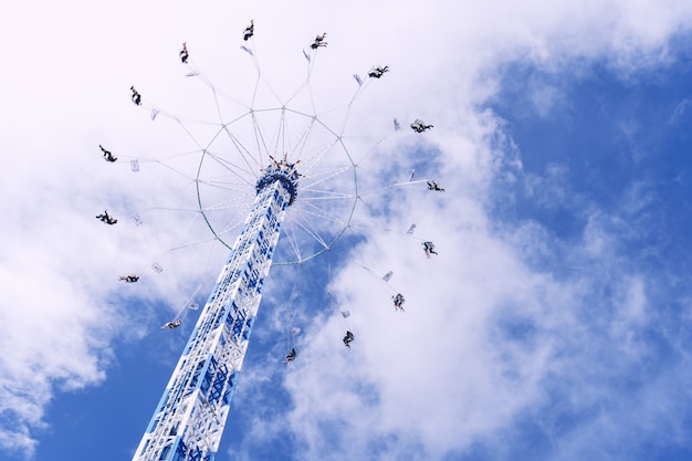 雲でいっぱいの空の下を回転する円形のカルーセルのローアングルショット