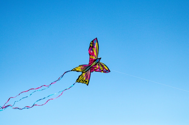 Low angle shot of a colorful kite with butterfly shape