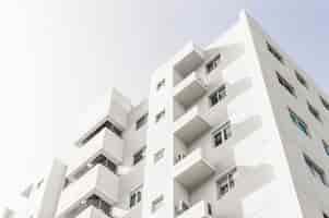 Free photo low angle shot of a facade of a white modern building under a blue clear sky