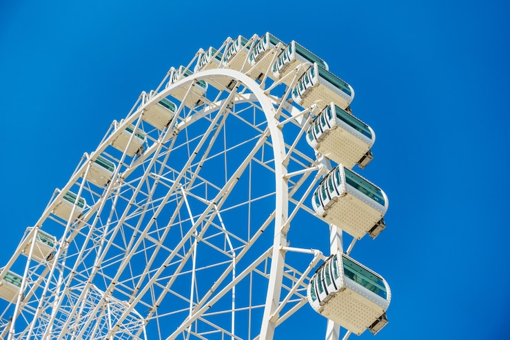 Free Photo low angle shot of a ferris wheel under a clear blue sky