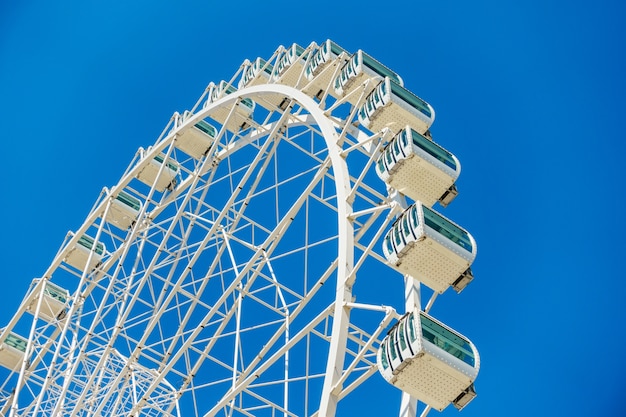 Снимок колеса обозрения под ясным голубым небом под низким углом