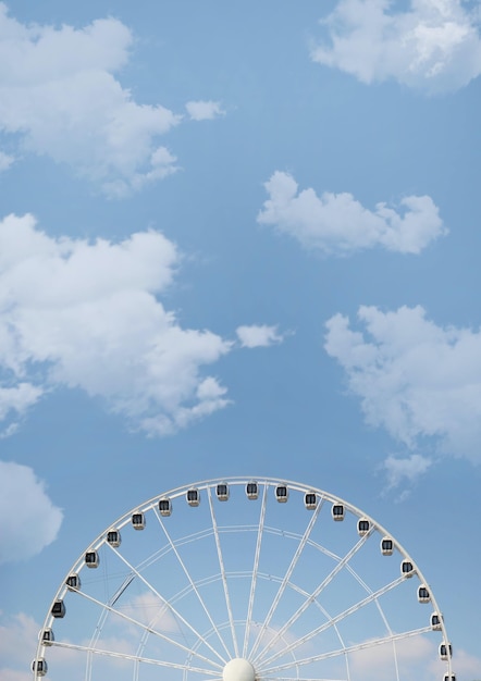 Low angle shot of a Ferris wheel on cloudy sky