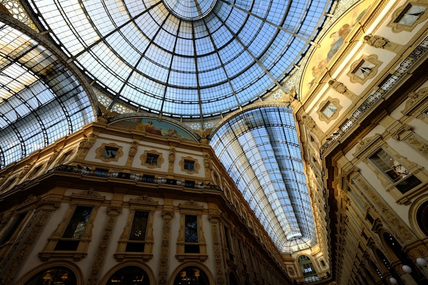 Low angle shot of glass ceiling with white and golden walls with pictures