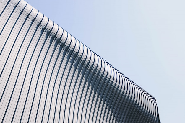 Low angle shot of a grey and white building roof with interesting textures under the blue sky