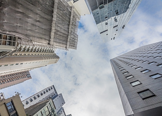 Foto gratuita inquadratura dal basso di alti edifici residenziali sotto il cielo nuvoloso