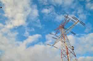 Foto gratuita inquadratura dal basso di un'alta torre di trasmissione con un cielo blu nuvoloso in