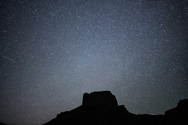 Low angle shot of a hill under a beautiful starry night sky