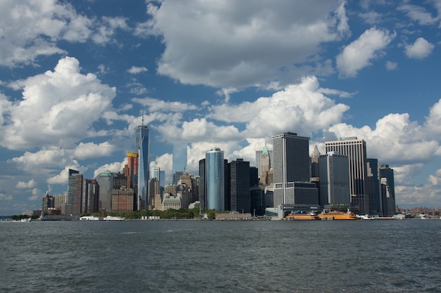 Low angle shot of an industrial city with skyscrapers at the edge of a sea and under the cloudy sky