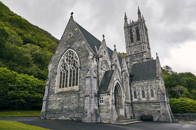緑に囲まれたアイルランドのカイルモア修道院のローアングルショット