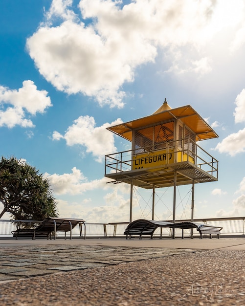 Foto gratuita inquadratura dal basso di una cabina del bagnino vicino al mare sotto il cielo nuvoloso