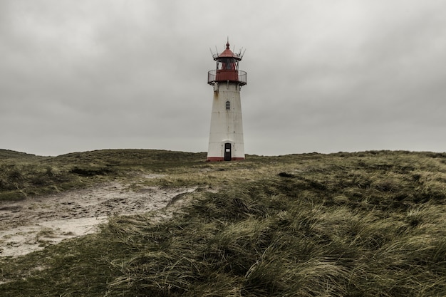 Foto gratuita colpo di angolo basso della lista del faro ad est a sylt, germania sotto le nuvole di tempesta