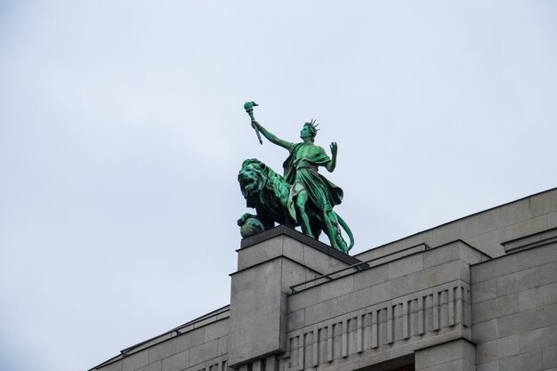 Low angle shot of the lion statue on the National Bank of the Czech Republic under a cloudy sky