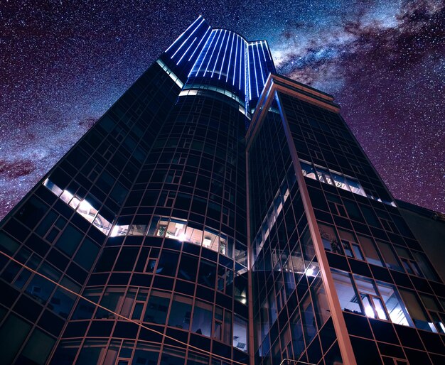 Low angle shot of a modern futuristic business architecture under a breathtaking starry sky