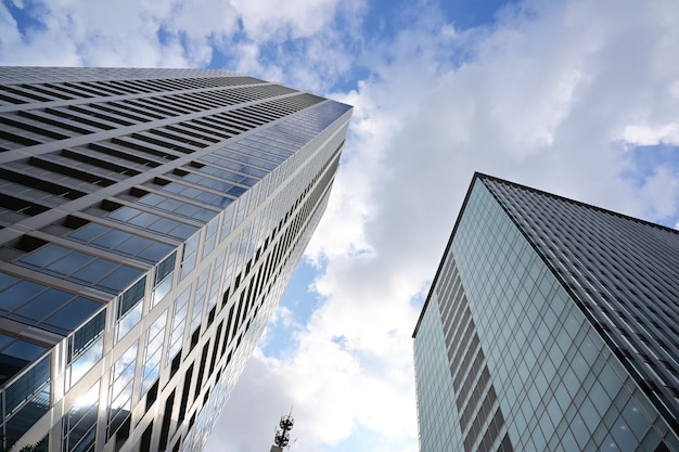 曇り空に対する現代のガラスの超高層ビルのローアングルショット