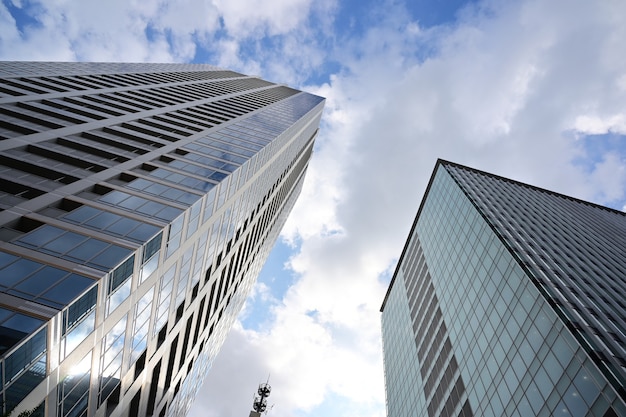 Low angle shot of modern glass skyscrapers against the cloudy sky