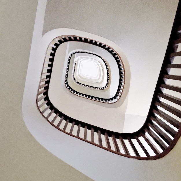 Низкий угол обзора современной винтовой лестницы в белом цвете