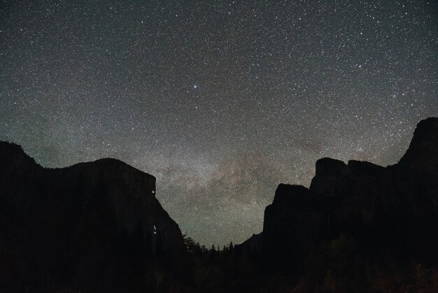 Low angle shot of a mountainous scenery under the magical night sky