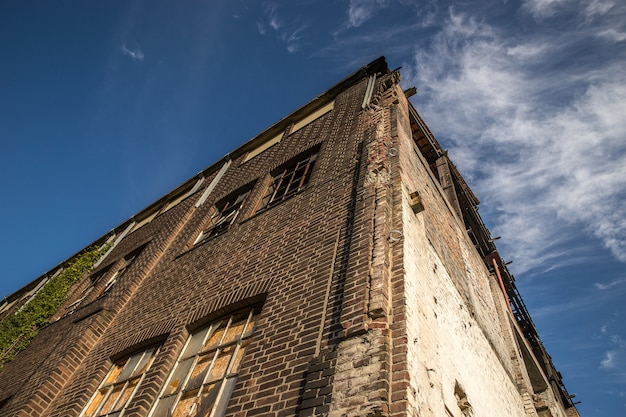 Low angle shot of an old stone building under the sky with a few clouds