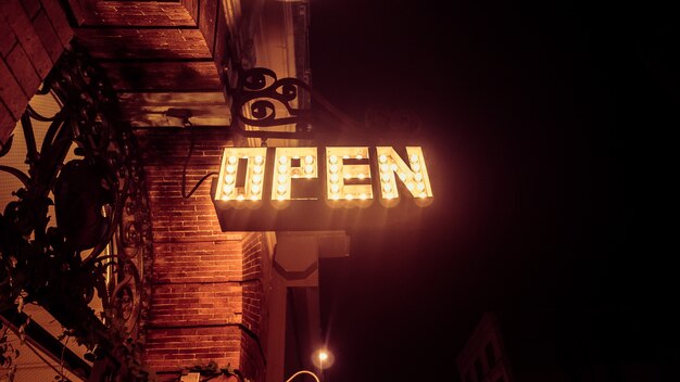 A low angle shot of an open sign made with lights