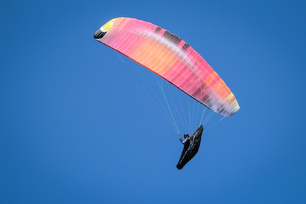 Снимок человека, летящего на параплане в солнечный день под ярким небом, под низким углом