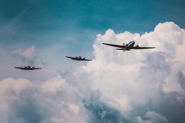 Free photo low angle shot of a range of aircraft preparing an air show under the breathtaking cloudy sky