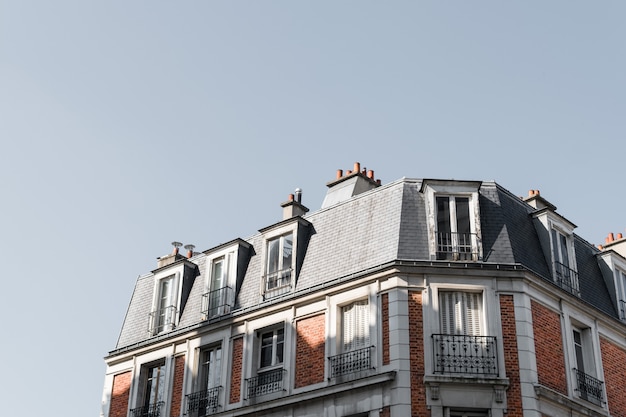 파리의 발코니가있는 아름다운 건물의 지붕의 낮은 각도 샷