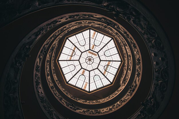 Low angle shot of a round ceiling with a window in a museum in Vatican during daytime