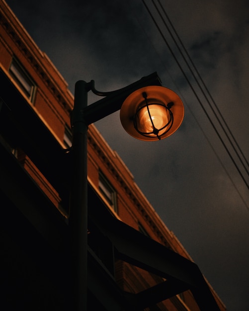 Free photo low angle shot of a rusty street lamp on a gray sky