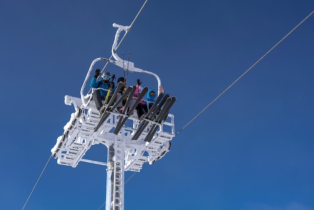 Low angle shot of skiers waving from the cable car