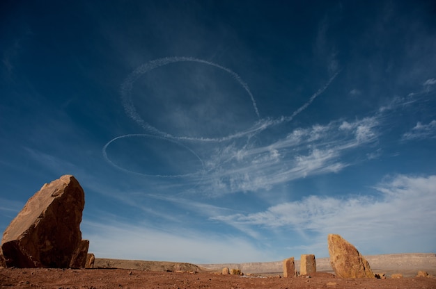 Inquadratura dal basso di tracce bianche a spirale nel cielo nel deserto