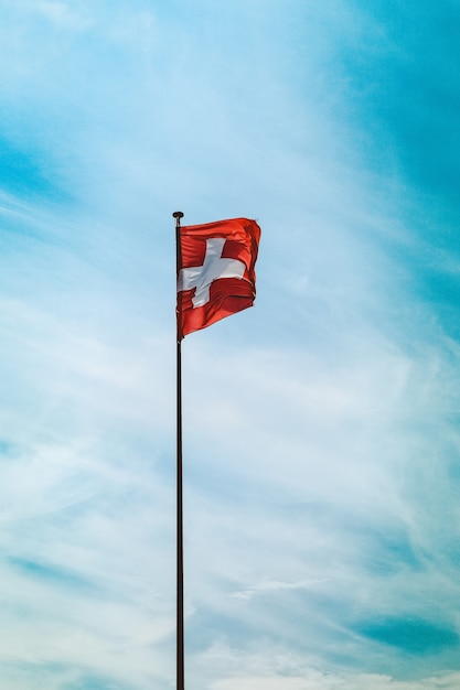 息をのむような曇り空の下でポールにスイス国旗のローアングルショット