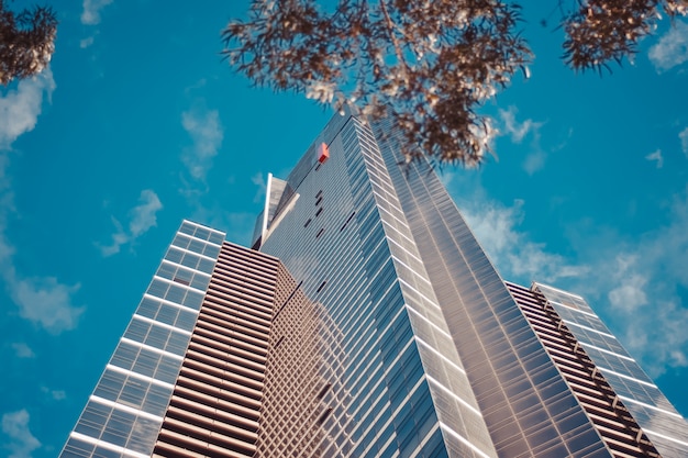 Low angle shot of a tall business building with a blue cloudy sky