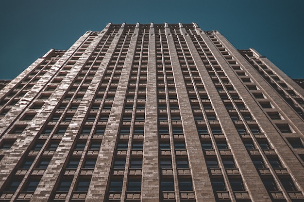 Low angle shot of a tall business building with a dark blue background