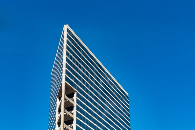 Low angle shot of tall glass buildings under a cloudy blue sky