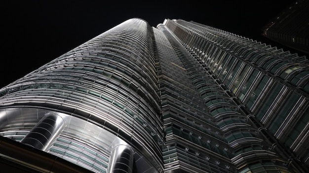 Low angle shot of a tall metal and glass building at night